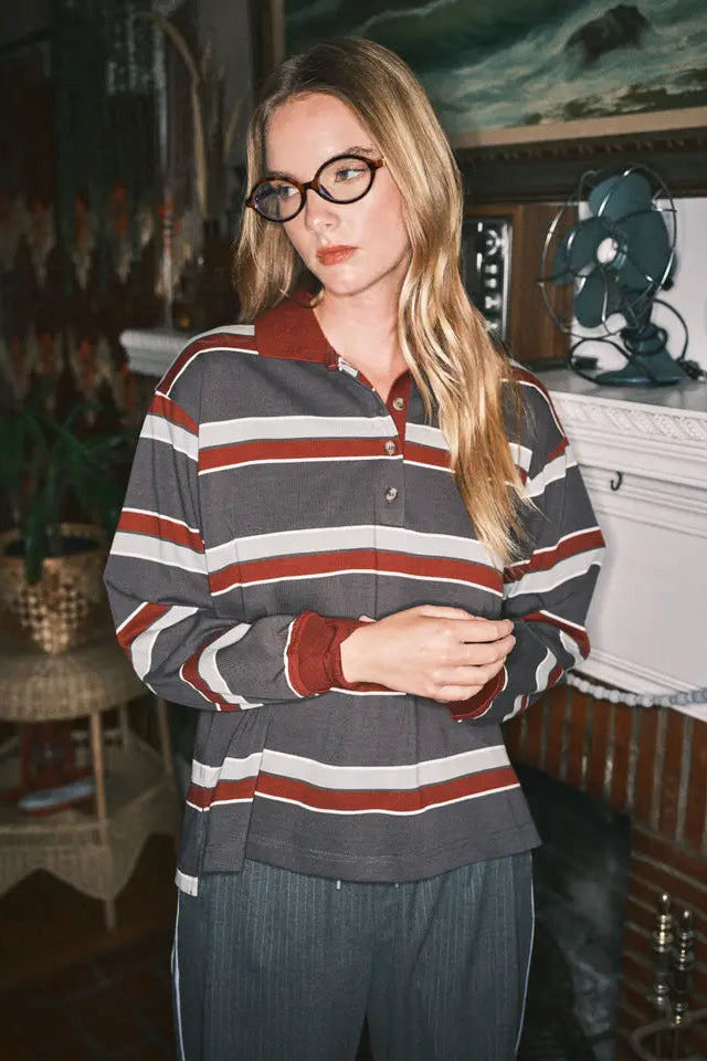 Person wearing a striped shirt in an indoor setting with decor elements.