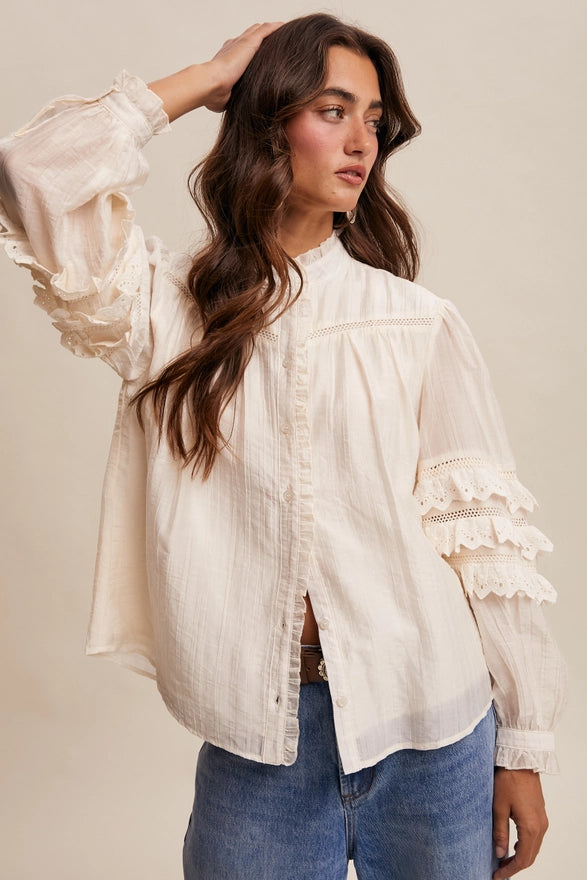 Woman wearing a white blouse with lace details on a beige background