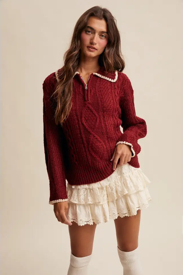 Woman wearing a red sweater and white skirt on a beige background