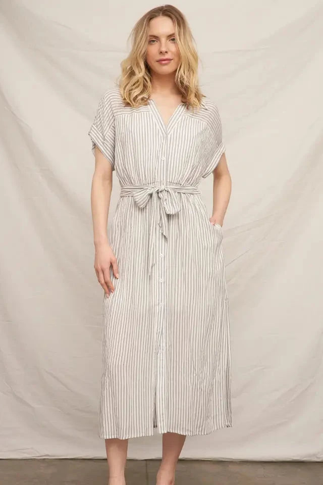 Woman wearing a striped dress against a plain background