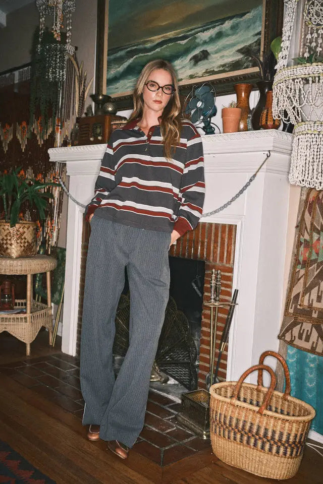 Woman standing in a room with a fireplace and decorative items