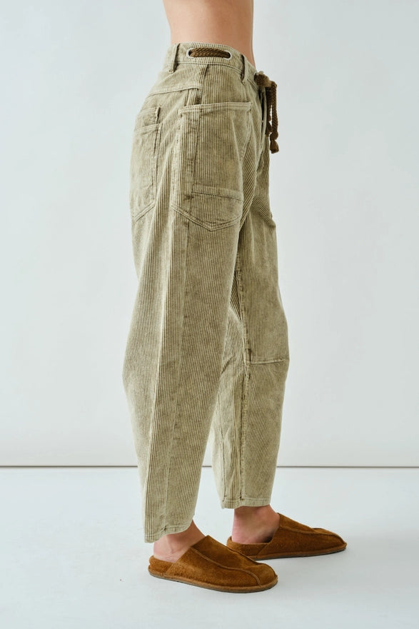 Person wearing beige cargo pants with a white background