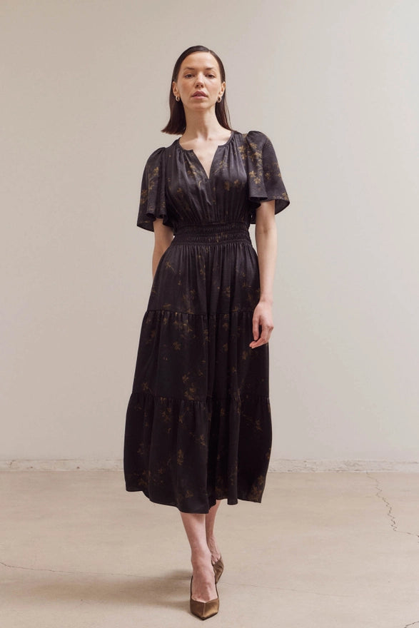 Woman wearing a black lace dress against a plain background