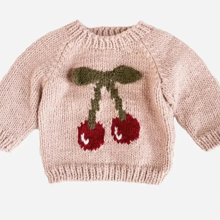 Knitted sweater with cherry design on a light background