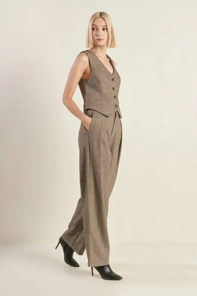 Woman wearing a brown checkered jumpsuit on a plain background