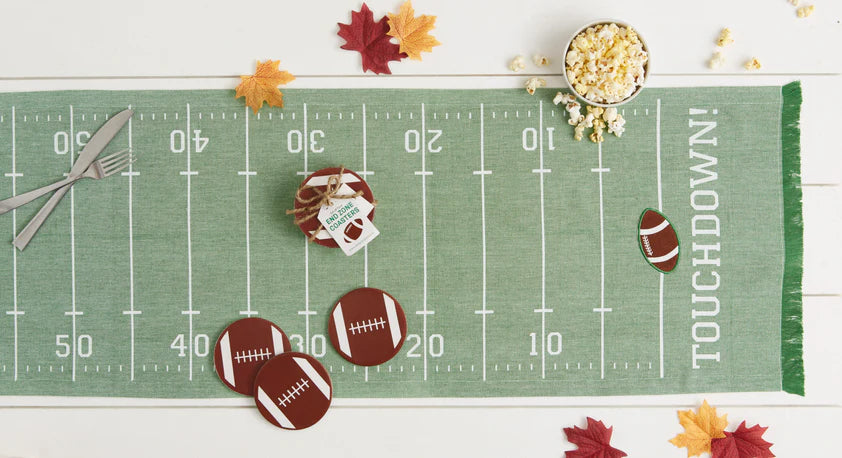 Football-themed table runner with decorative items on a white surface