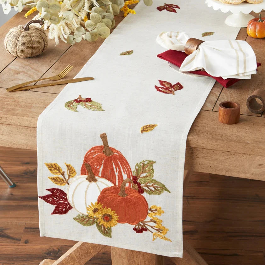 Table runner with pumpkins and leaves on a wooden table