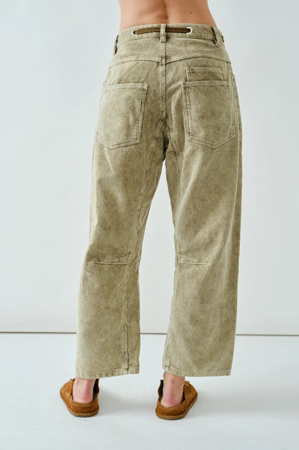 Person wearing beige corduroy pants on a white background