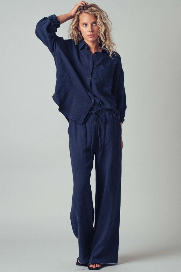 Woman wearing a navy blue outfit against a plain background