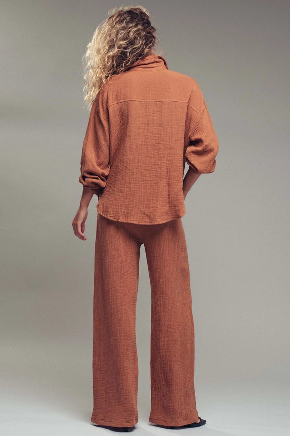 Person wearing a brown corduroy outfit on a plain background