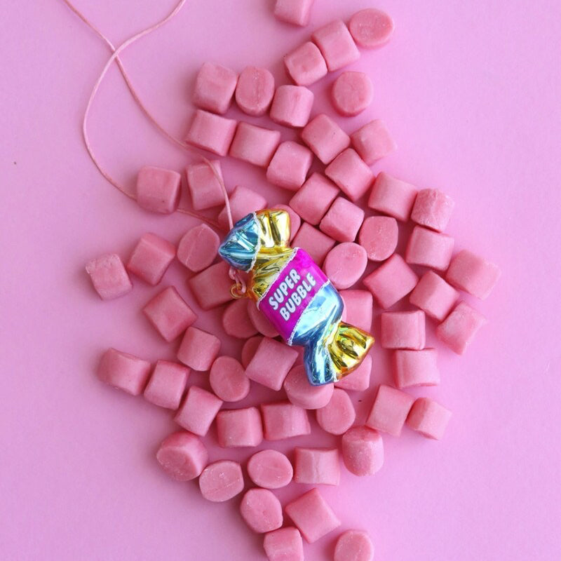 Pink candy with a colorful wrapper on a pink background