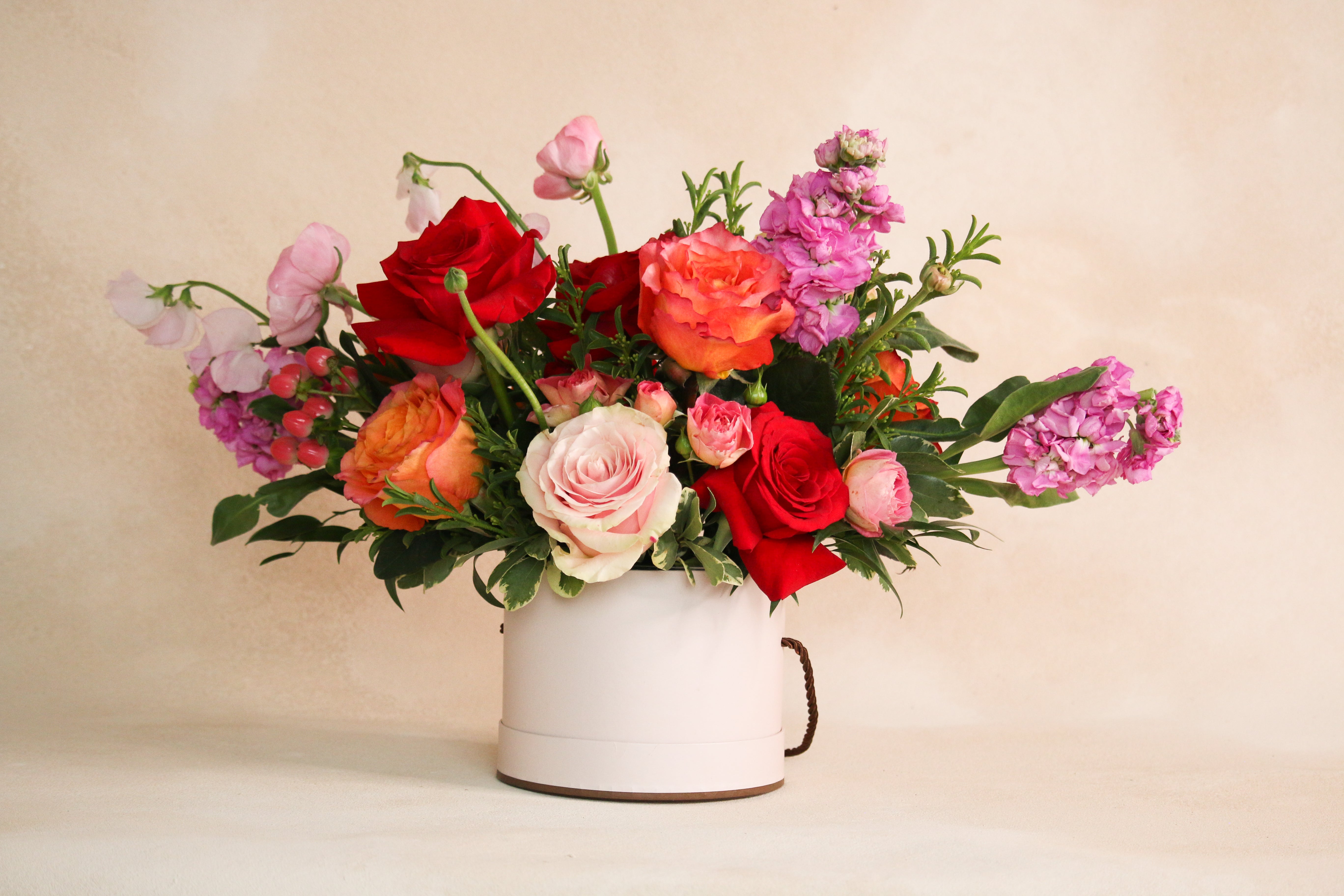 Floral vase arrangement with red pink orange roses