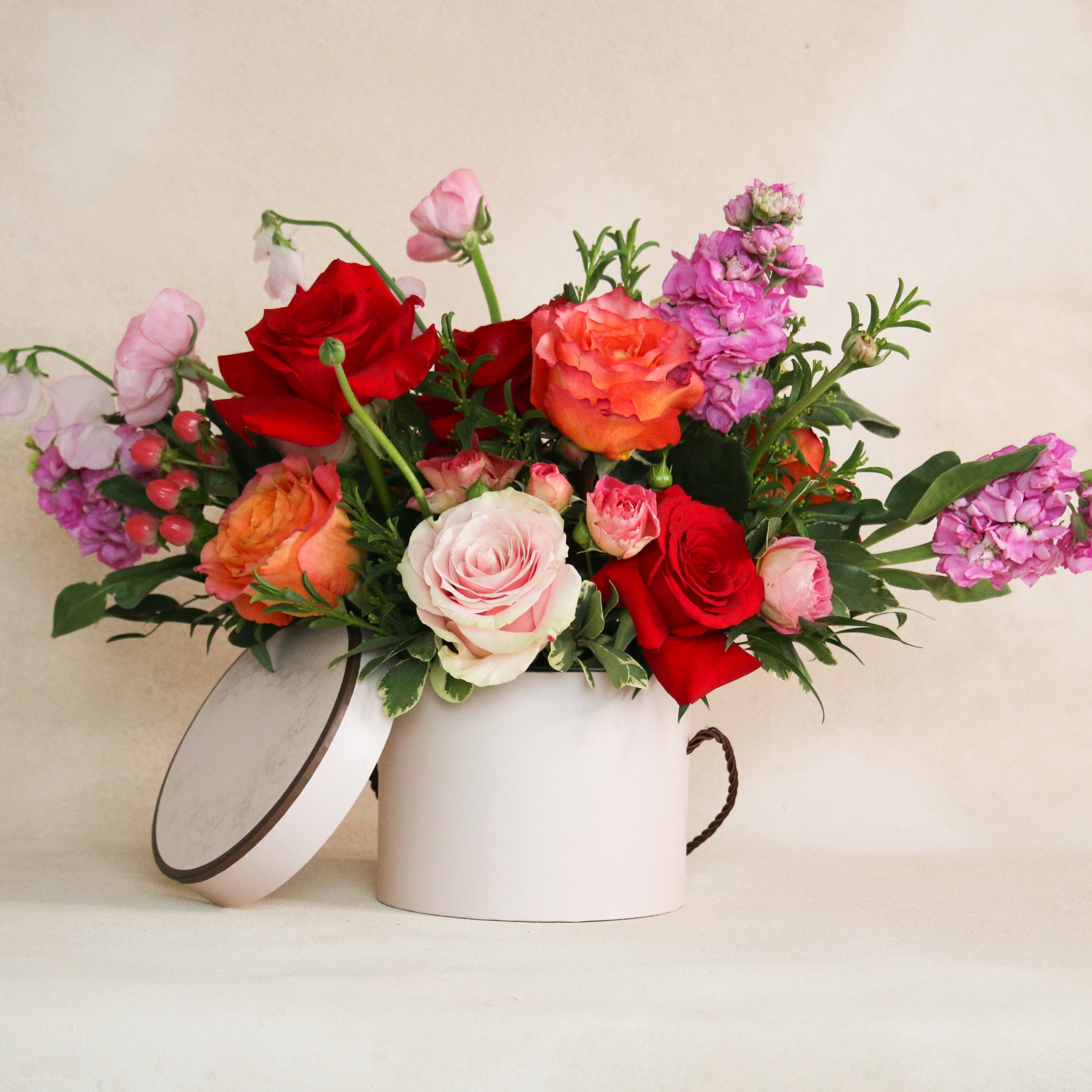 Floral vase arrangement with red pink orange roses