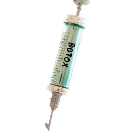 A Botox wrinkle free ornament designed to resemble a syringe with a green barrel and white needle, with the text 'BOTOX' printed on the barrel.