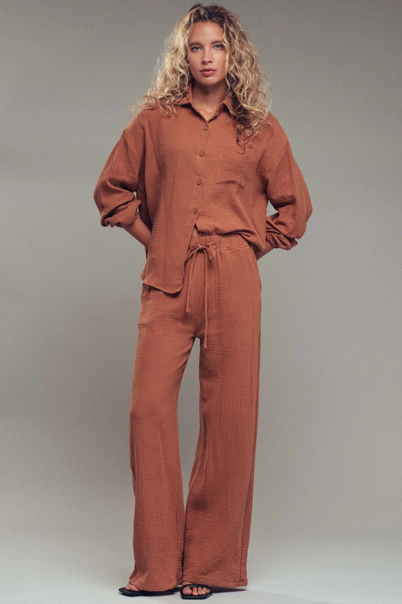 Woman wearing a brown outfit against a plain background