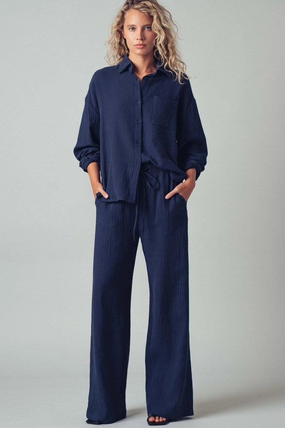 Woman wearing a navy blue outfit against a plain background