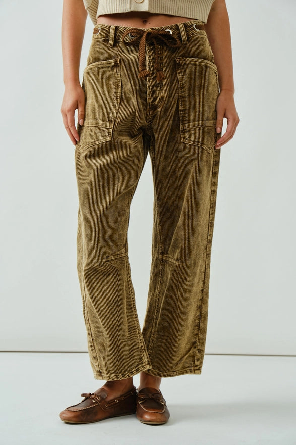Person wearing brown corduroy pants on a white background