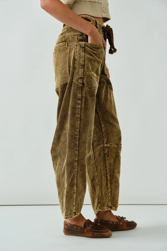 Person wearing brown corduroy pants on a white background