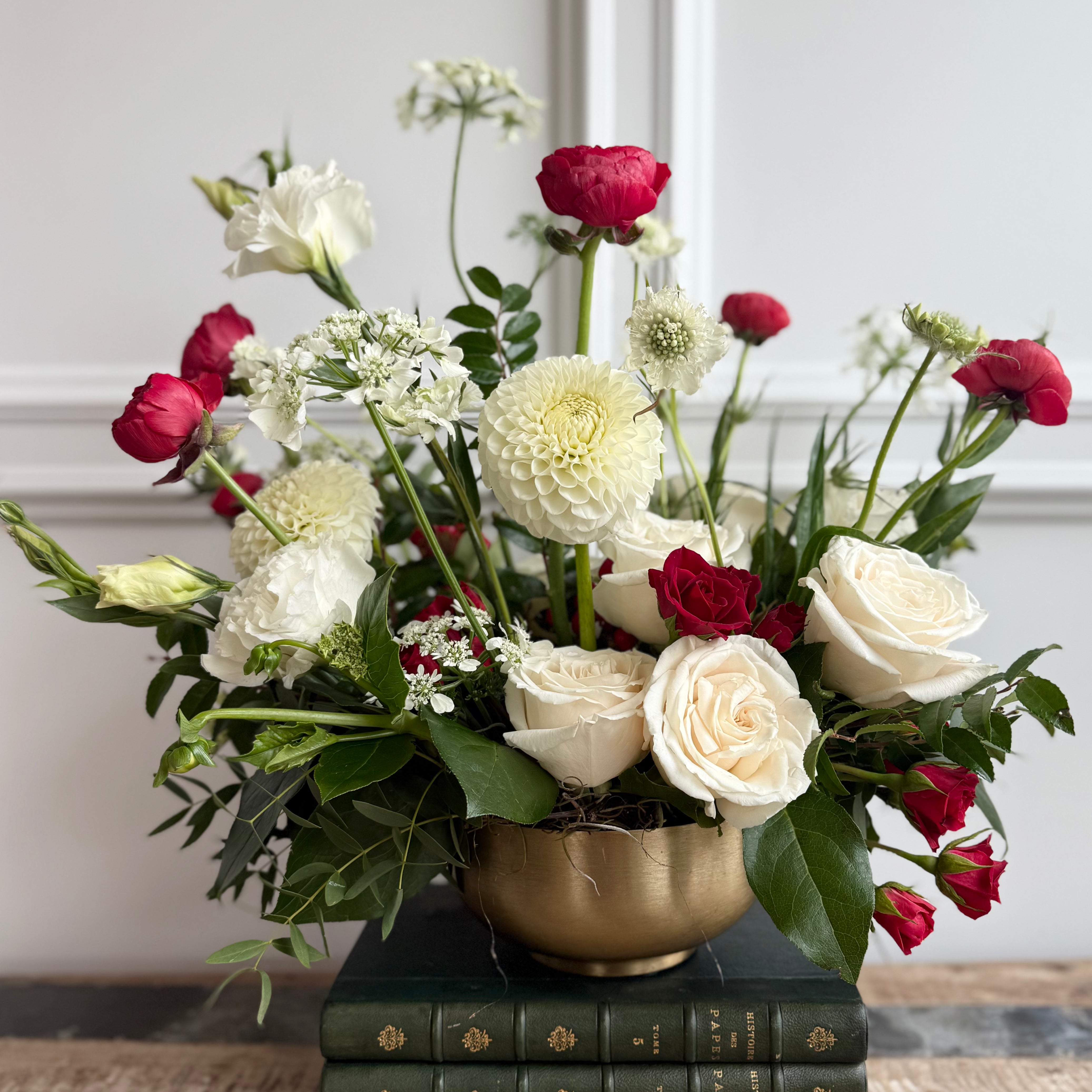 Bouquet features red accents against crisp white blooms and lush greenery.