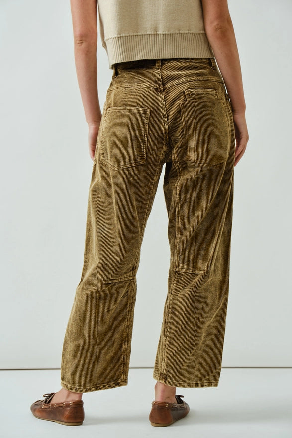 Person wearing brown corduroy pants on a white background