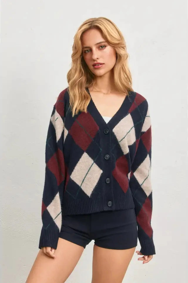 Woman wearing a patterned cardigan on a plain background