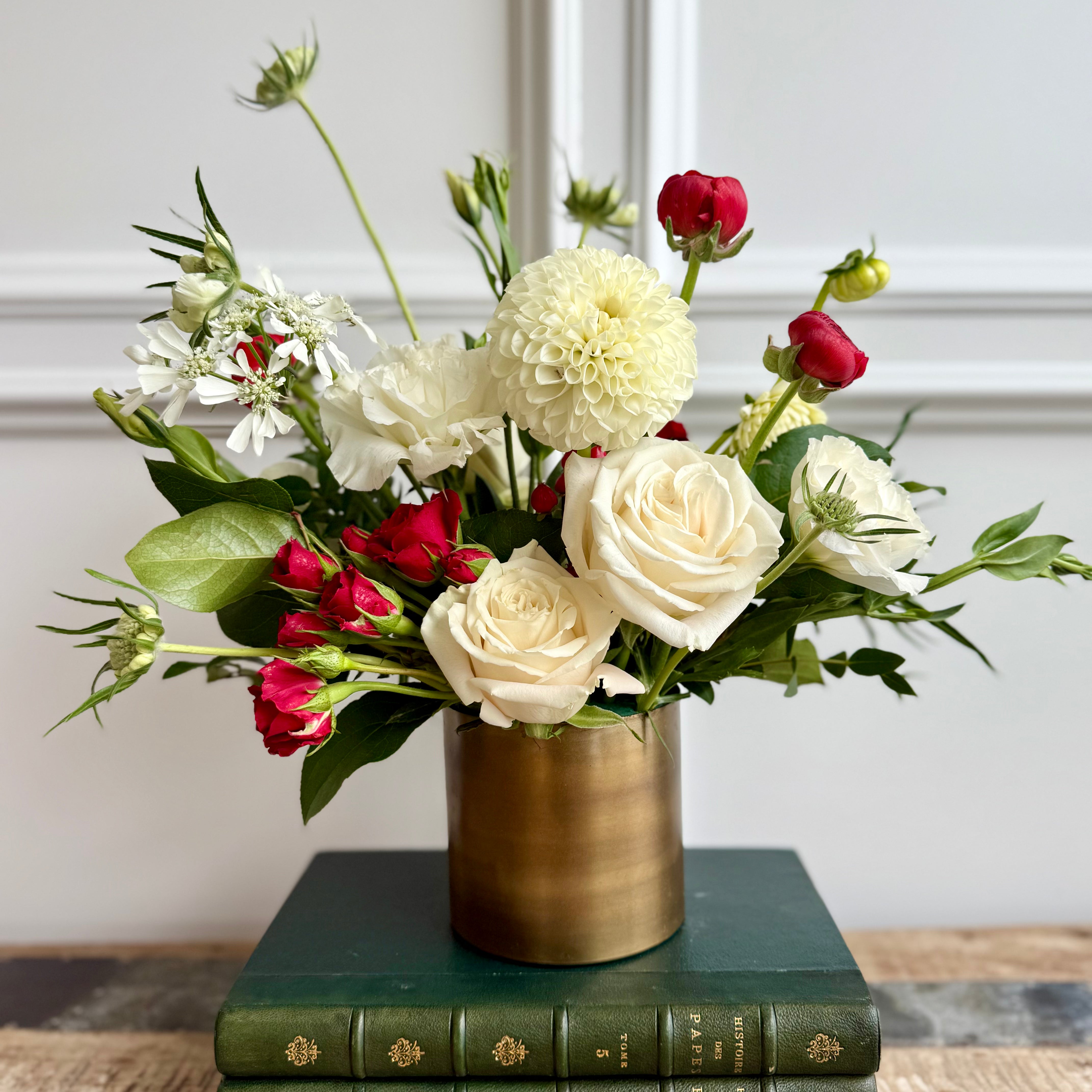 Bouquet features red accents against crisp white blooms and lush greenery.
