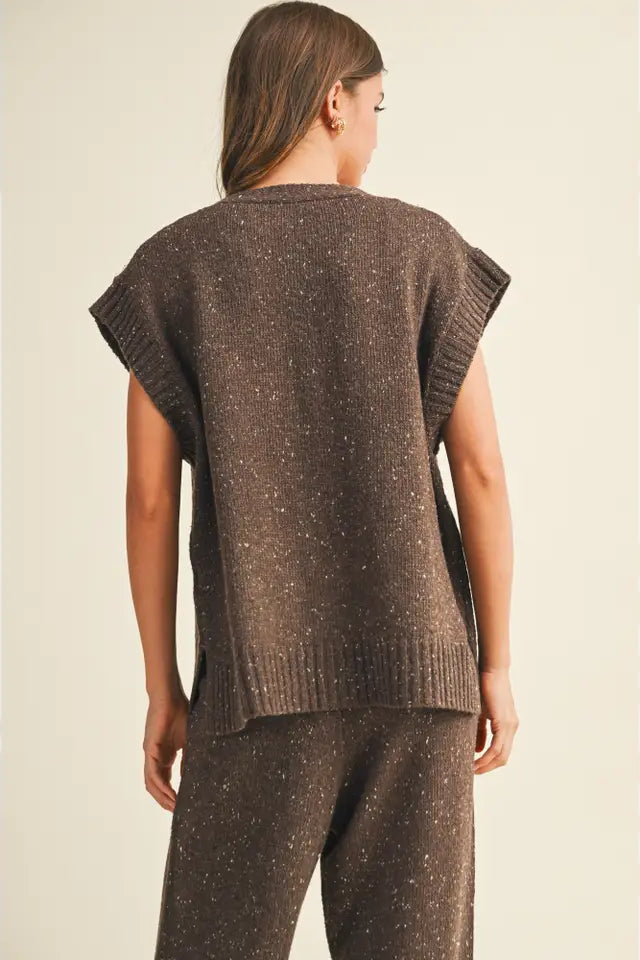 Woman wearing a brown knitted sleeveless top and pants on a beige background