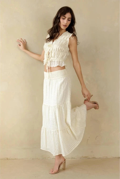 Woman wearing a white dress against a beige background