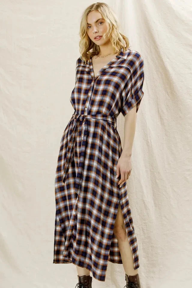 Woman wearing a plaid dress against a plain background