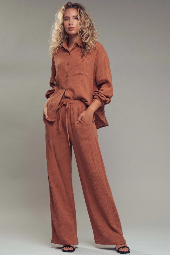 Woman wearing a brown outfit against a plain background