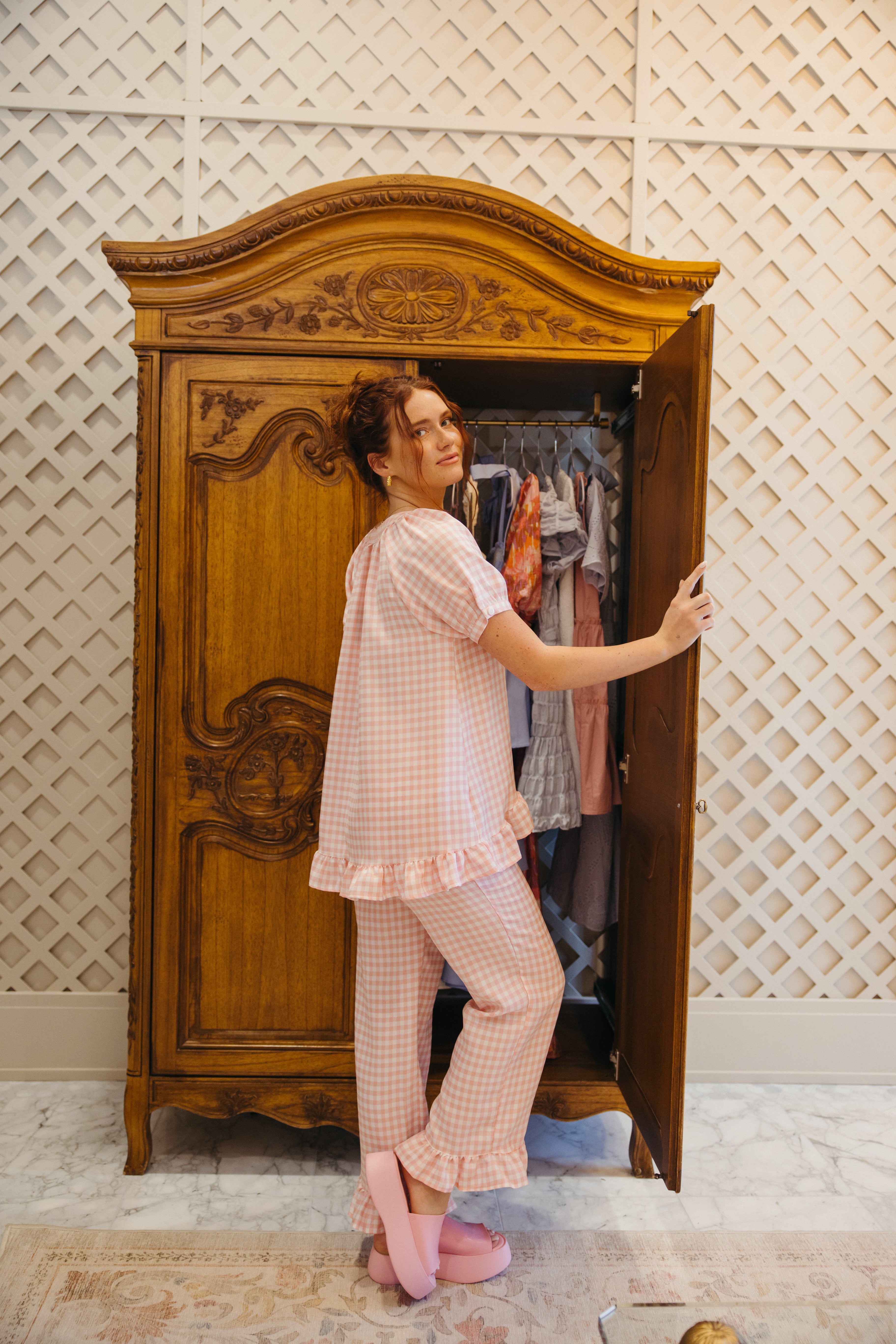 Model is wearing gingham pajama set with short sleeve and pant.
