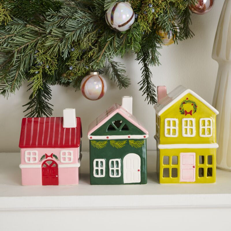 Decorative houses on a shelf with Christmas decorations