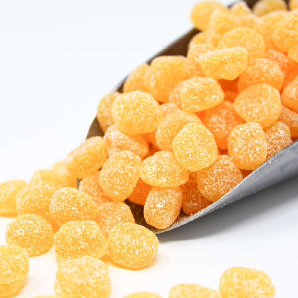 Sugared sour peaches candy in a scoop