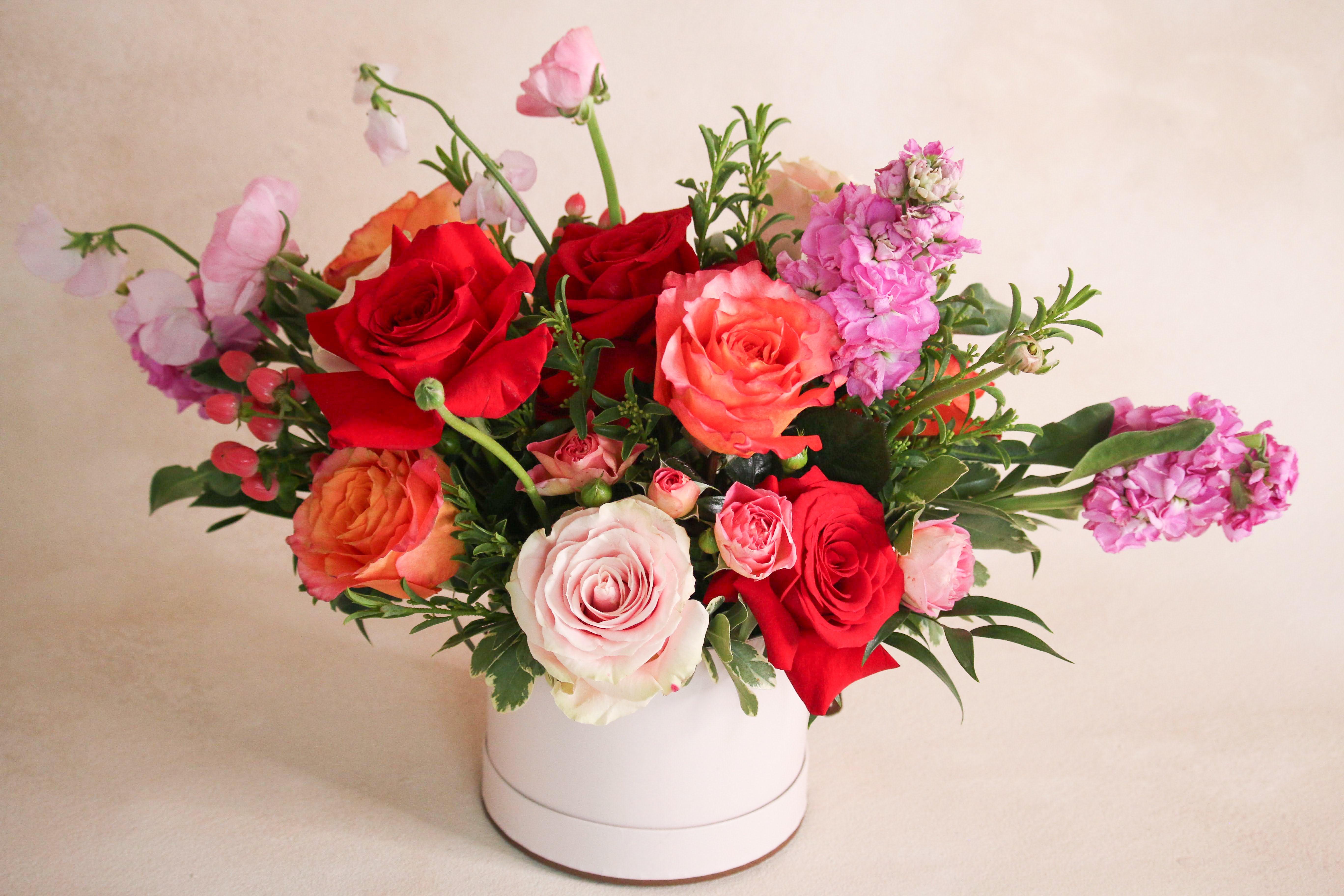 Floral vase arrangement with red pink orange roses