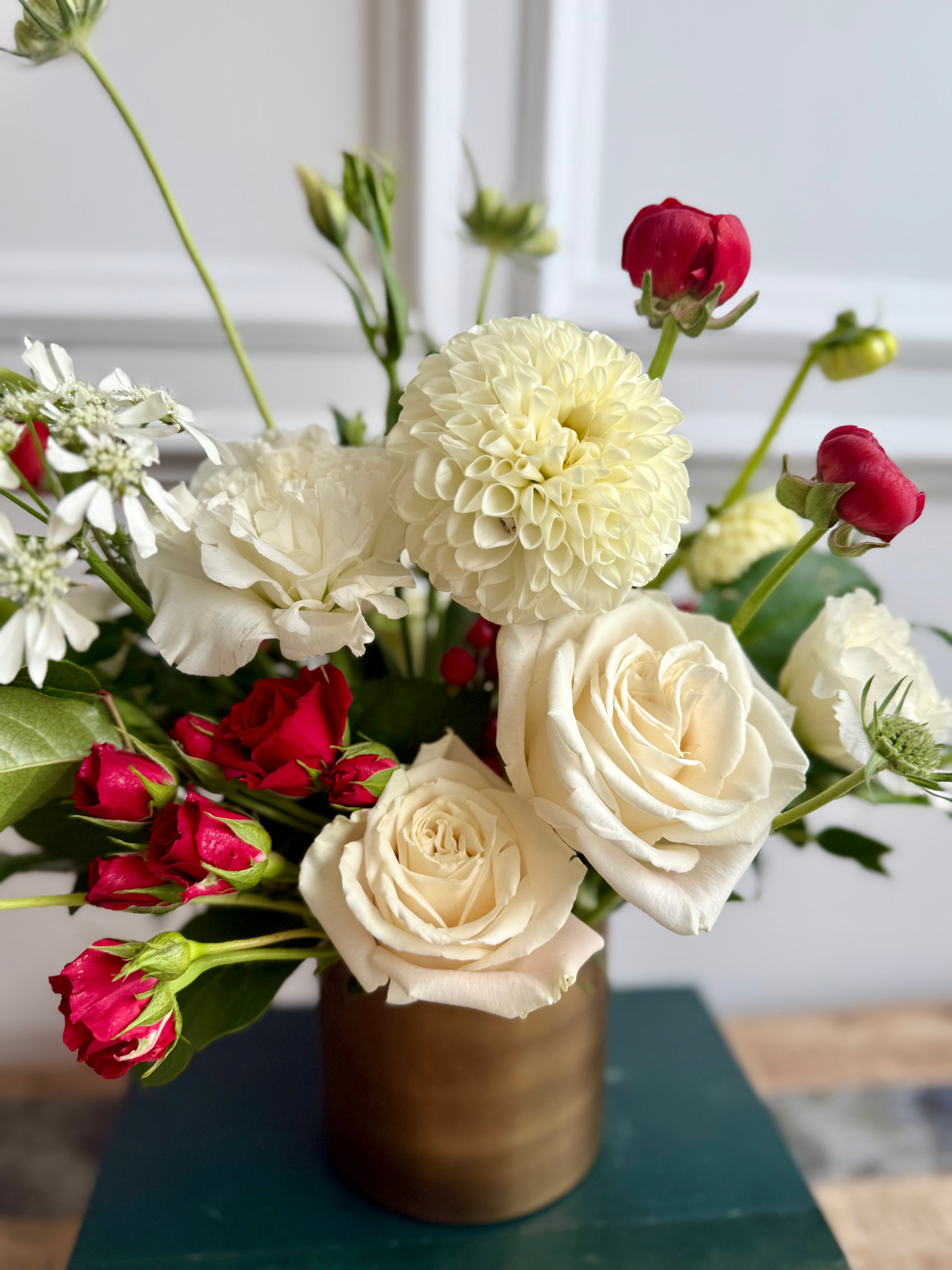 Bouquet features red accents against crisp white blooms and lush greenery.