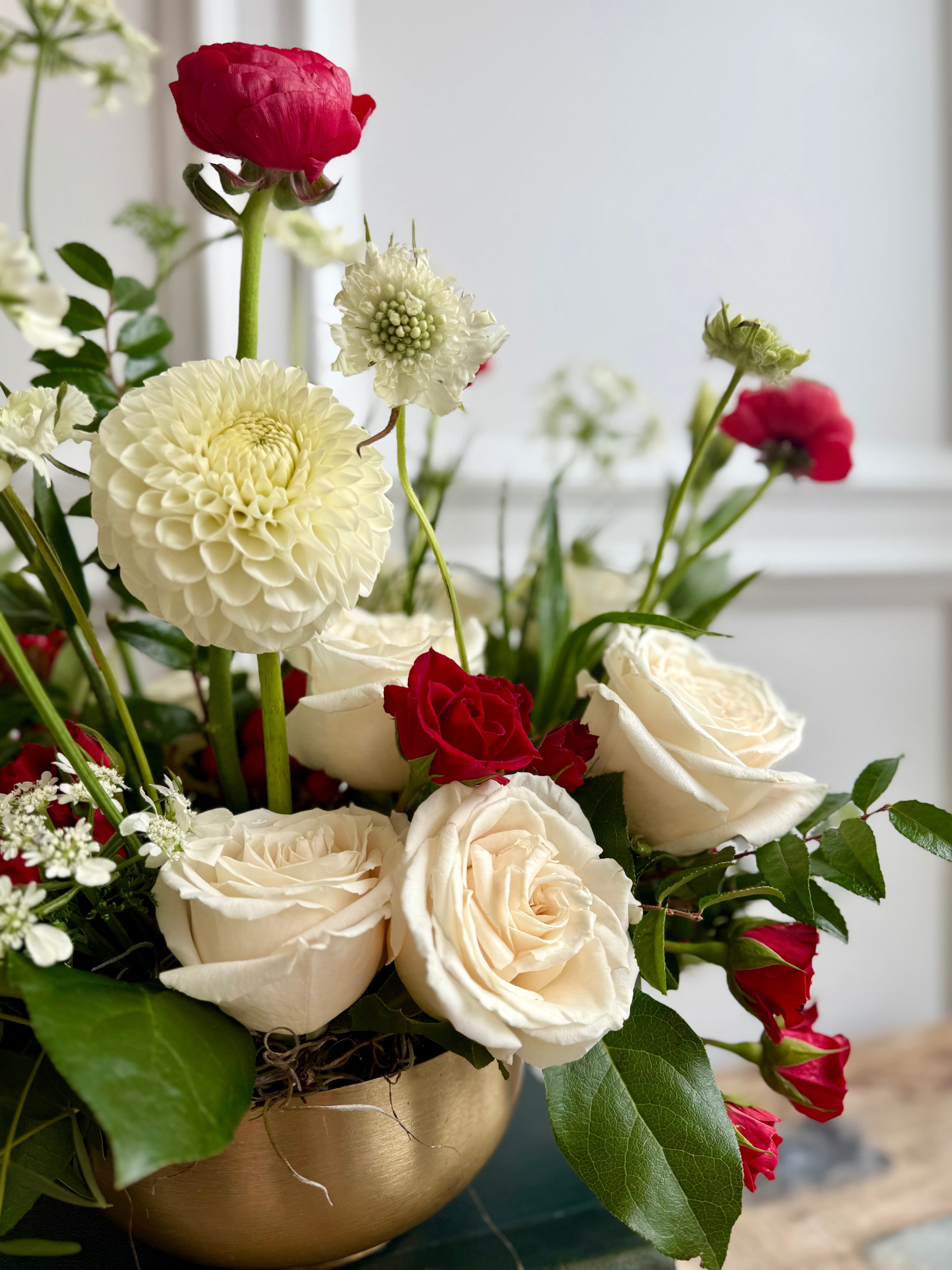 Bouquet features red accents against crisp white blooms and lush greenery.
