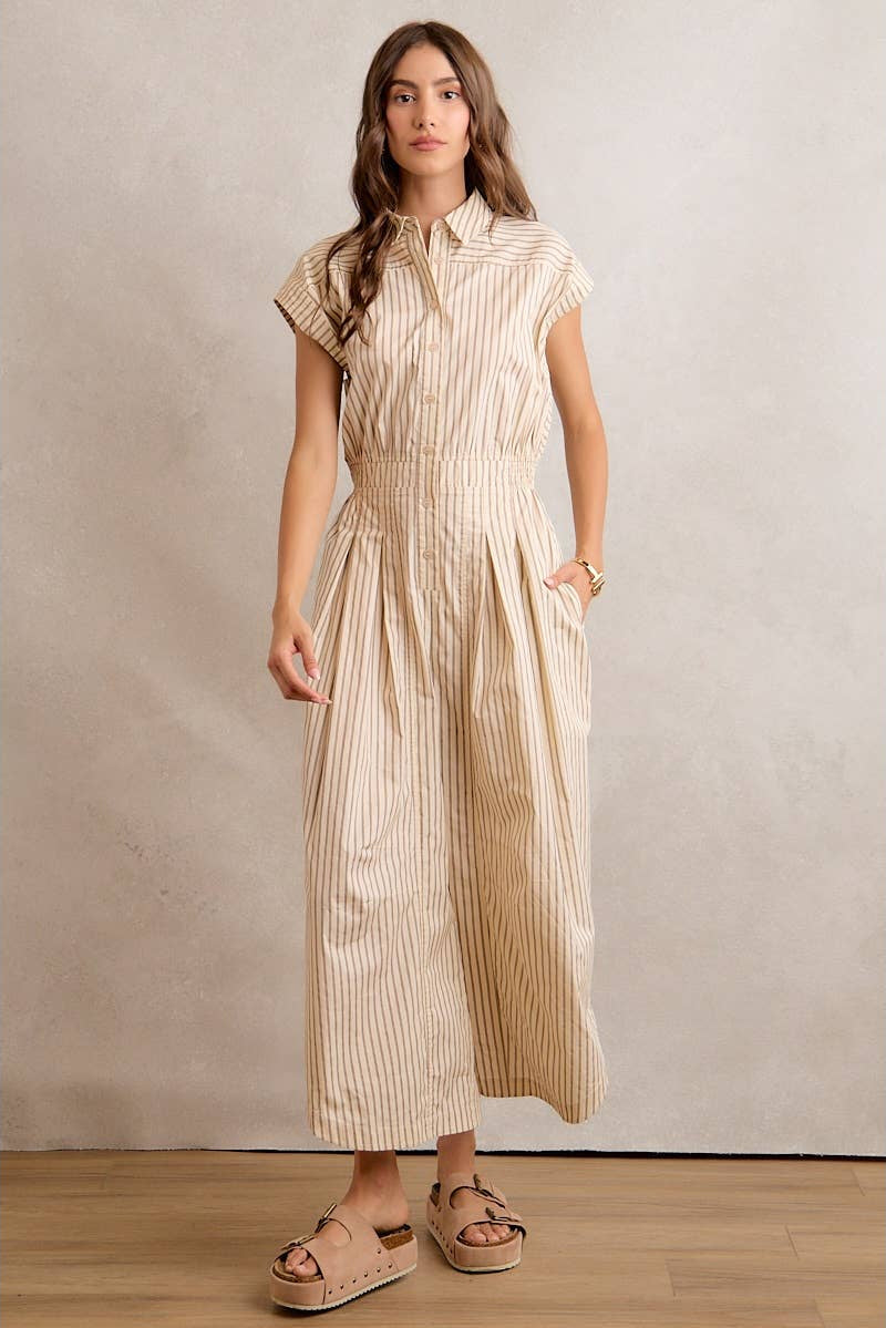 Woman wearing a beige striped dress against a plain background