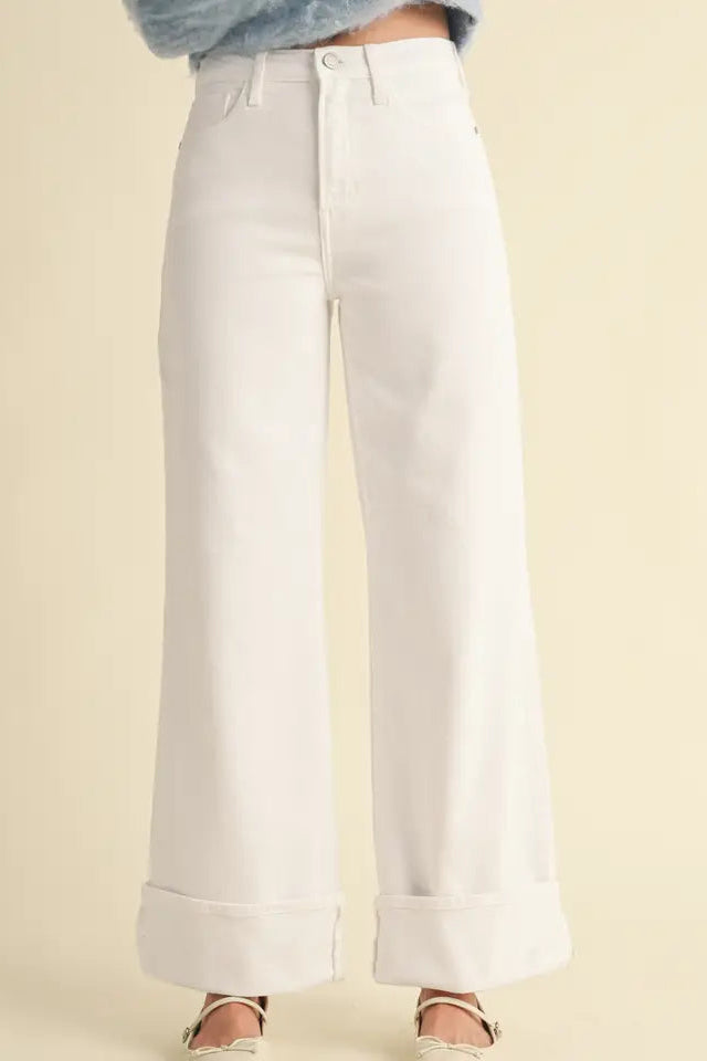 White wide-leg pants worn by a person on a beige background