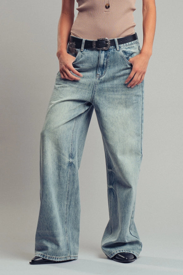 Person wearing light blue jeans on a plain background