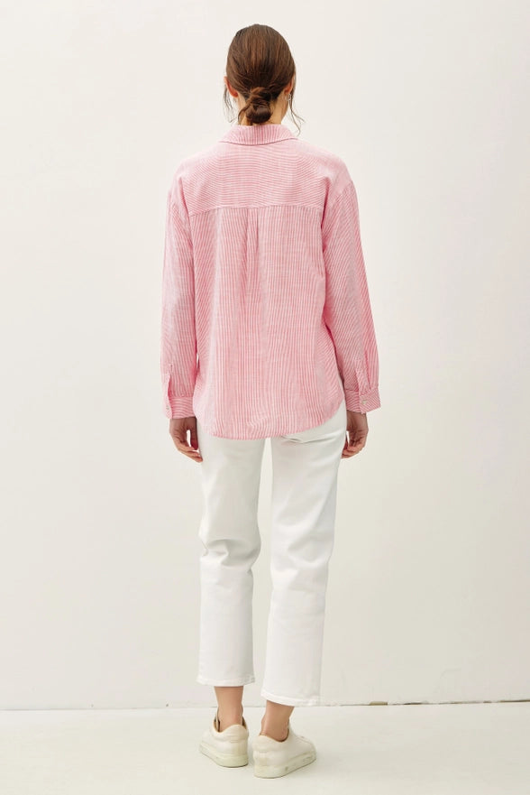 Person wearing a pink checkered shirt and white pants on a white background