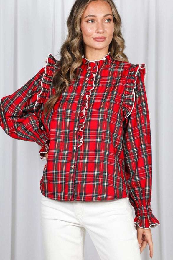 Woman wearing a red plaid blouse with white buttons against a white background