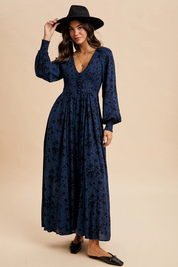 Woman wearing an indigo floral maxi dress on plain background. 