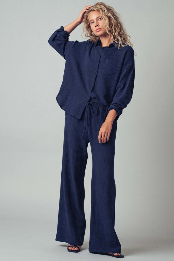 Woman wearing a navy blue outfit against a plain background