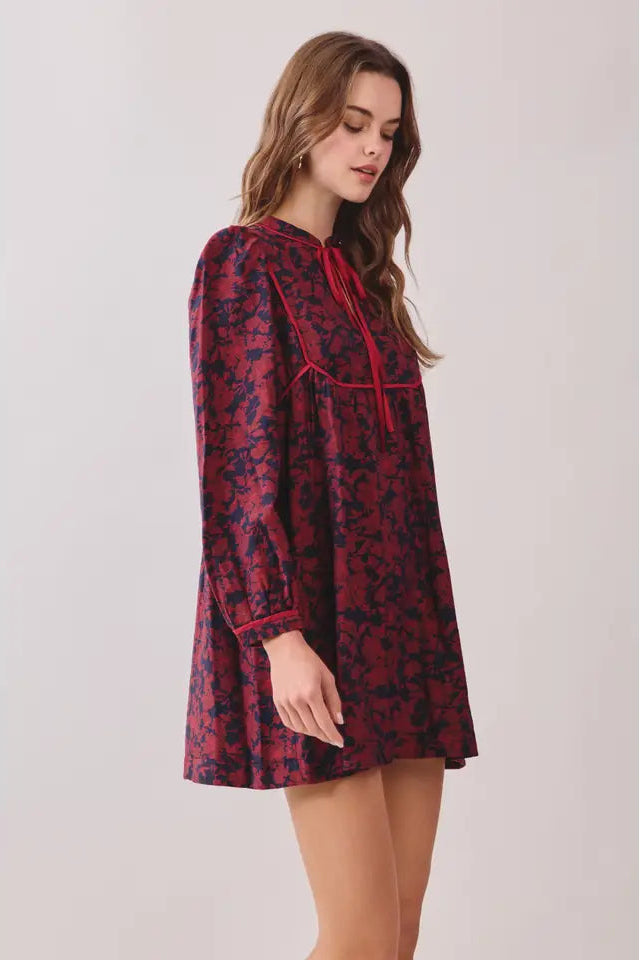 Woman wearing a red and black patterned dress on a white background