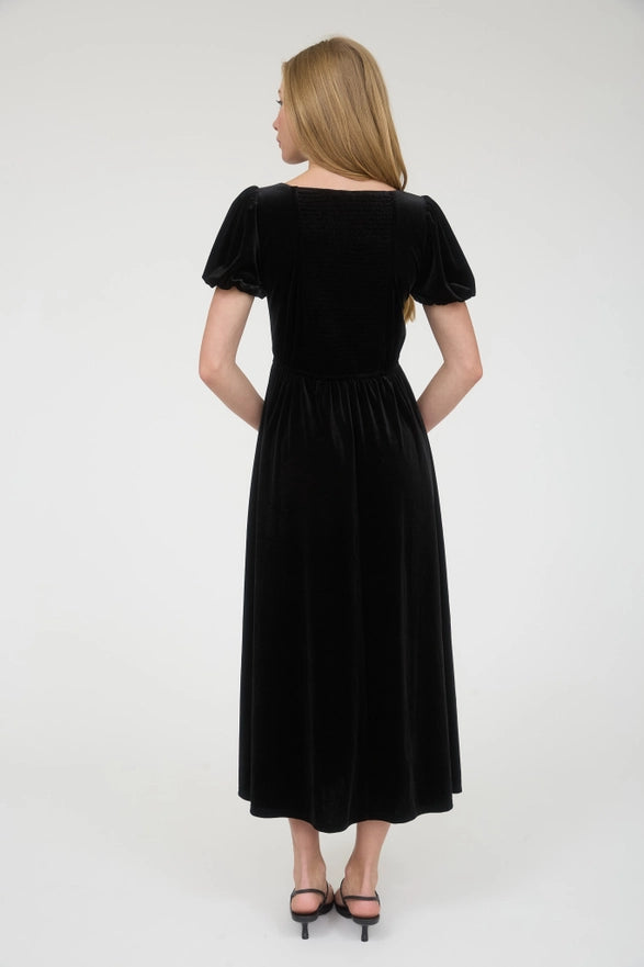 Woman wearing a black dress against a white background