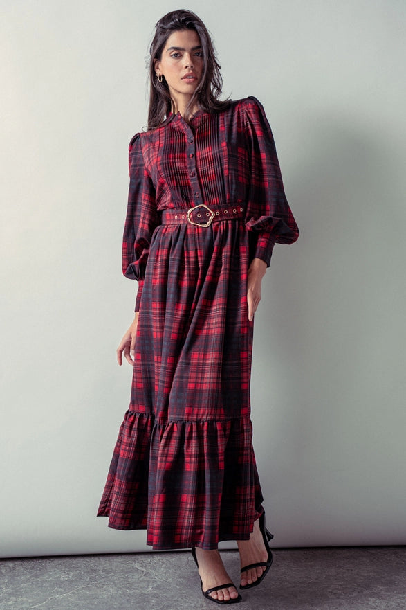 Woman wearing a red plaid maxi dress against a plain background.