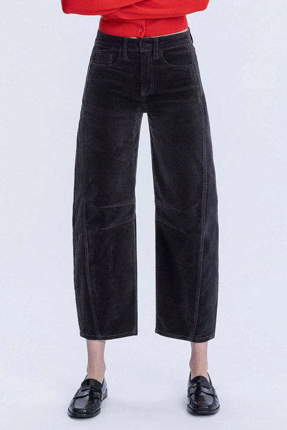 Person wearing black wide-leg pants on a white background