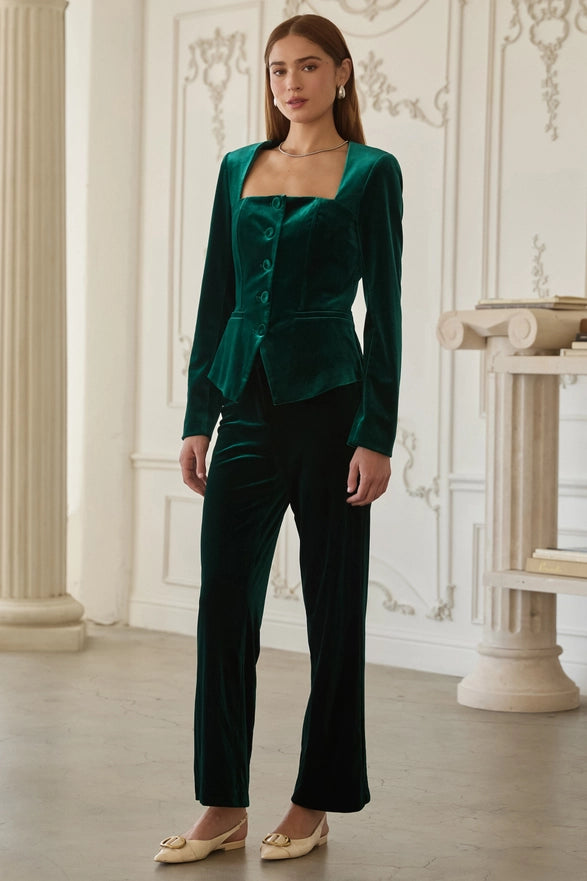 Woman wearing a green velvet suit in an elegant room.