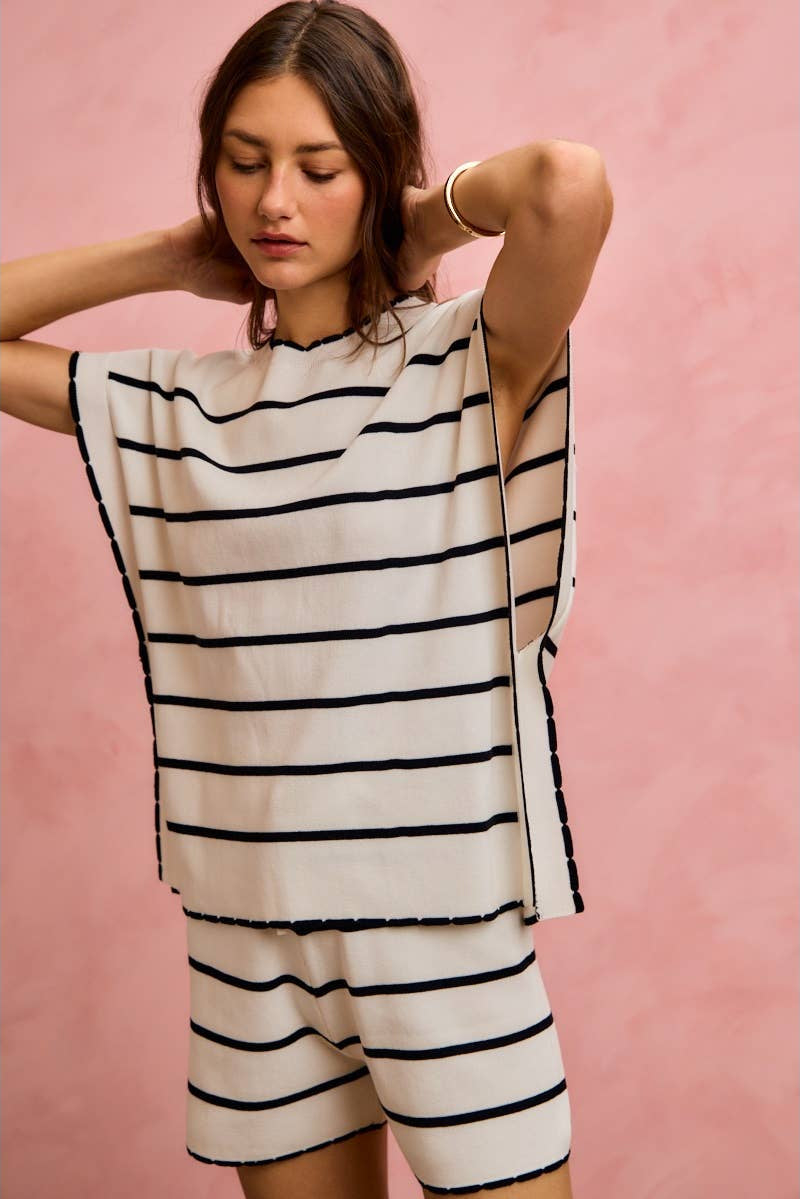 Woman wearing a black and white striped outfit against a pink background