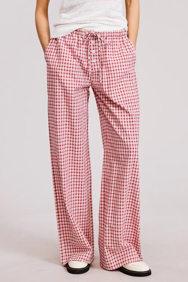Person wearing red and white checkered pants on a plain background